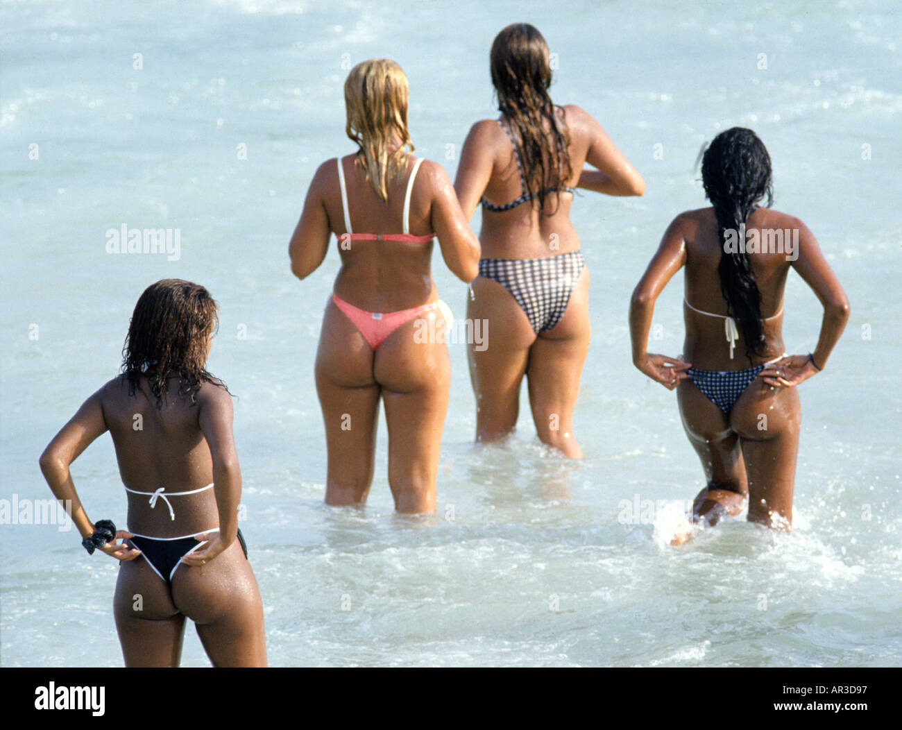 A group of young women adjust their thong bikinis while entering the water  at Ipanema beach in Rio de Janeiro Brazil Stock Photo - Alamy