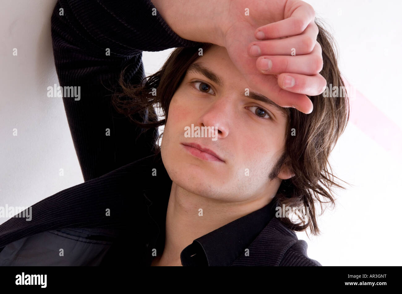 young man leaning against a wall Stock Photo - Alamy