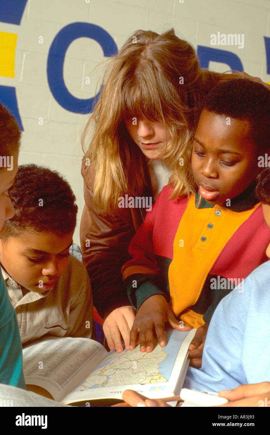 Tutor and youths age 20 and 10 in community after school study program. St Paul Minnesota USA Stock Photo