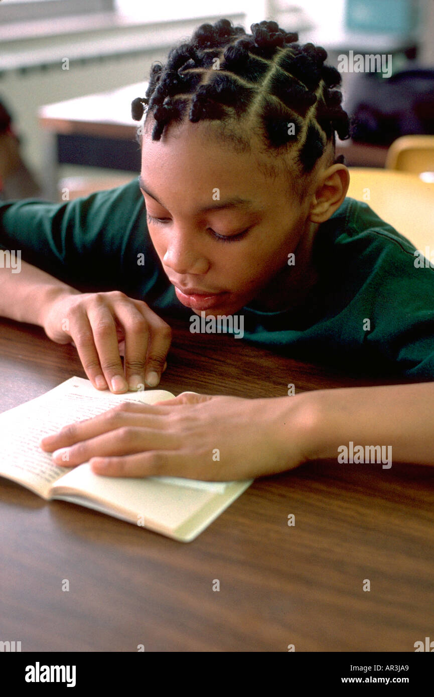 Youth age 12 reading in community after school study program. St Paul Minnesota USA Stock Photo