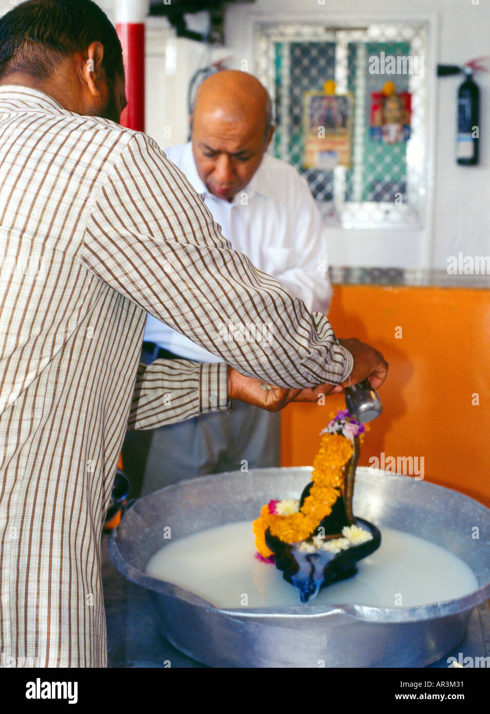Dubai UAE Hindu Temple Bathing Lingum with Milk Stock Photo
