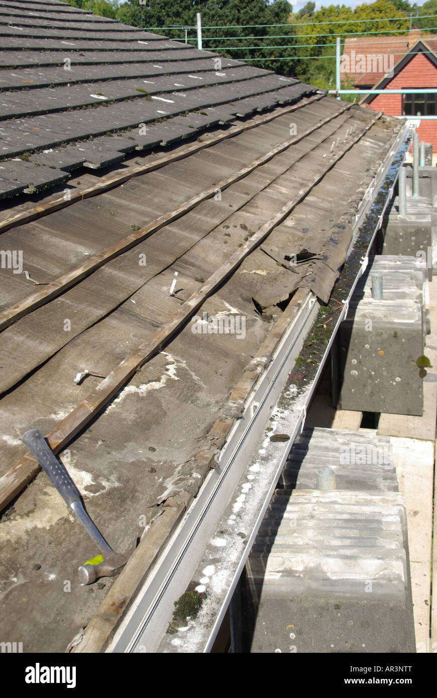 Roof repair required to under felt & battens below eaves tiles on detached  house where felt has deteriorated at gutter line Stock Photo - Alamy