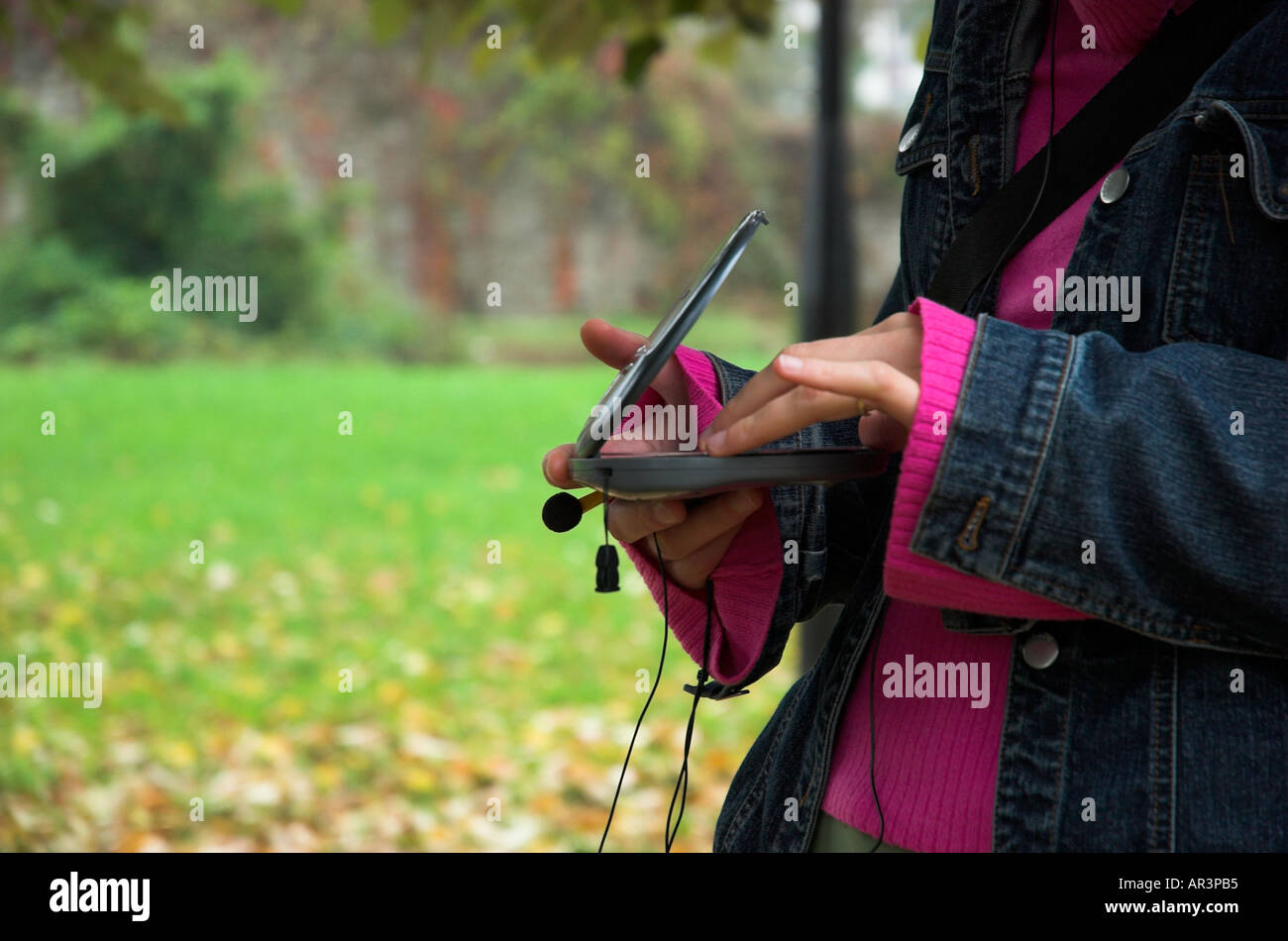 Young woman in park listening music Stock Photo