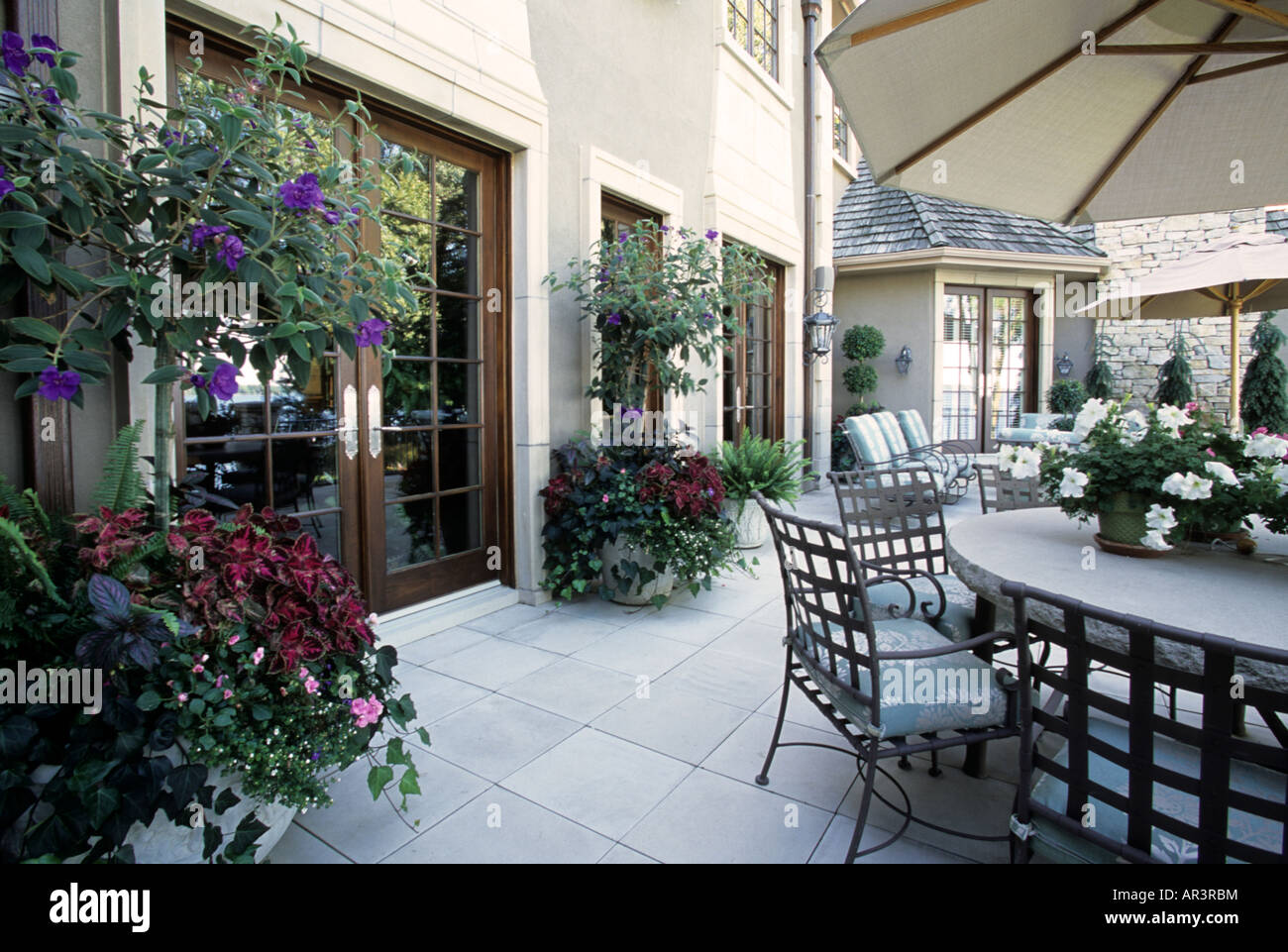 PATIO OF UPSCALE MINNESOTA HOME DECORATED WITH CONTAINER AND HANGING PLANTS TO ADD COLOR.  SUMMER.  AMERICA. Stock Photo
