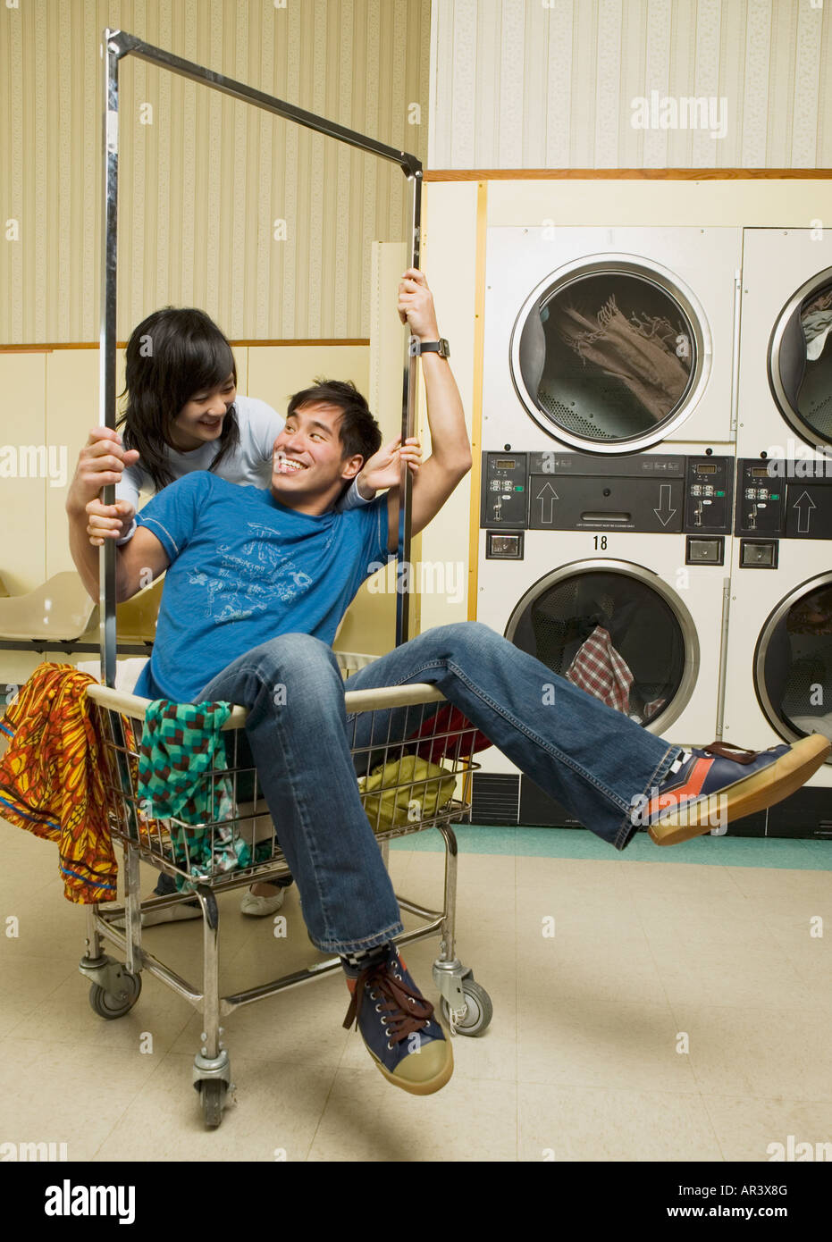 Asian couple in Laundromat Stock Photo - Alamy