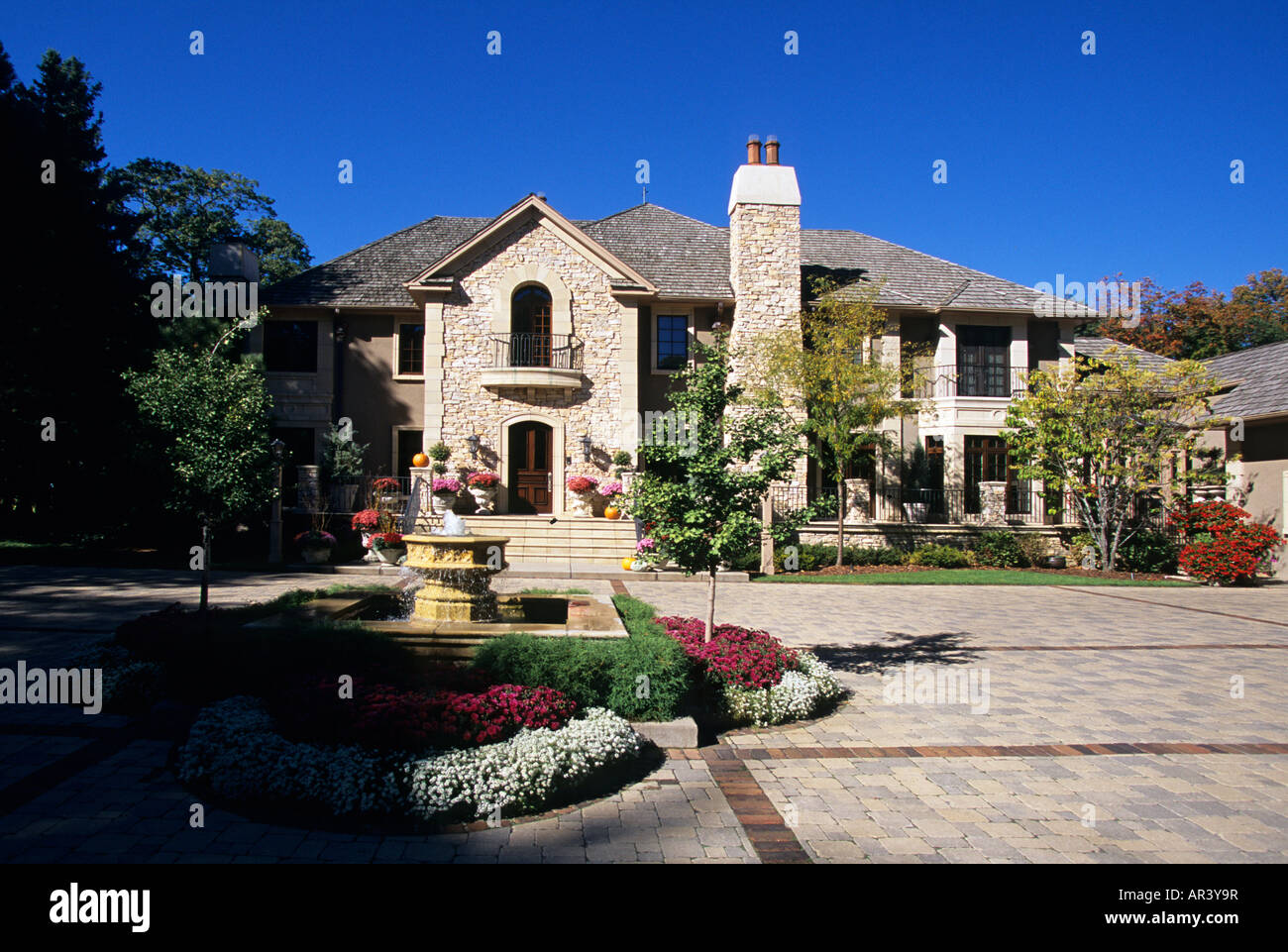 FRONT ENTRANCE GARDEN OF LUXURY MINNESOTA HOME INCLUDES A FOUNTAIN