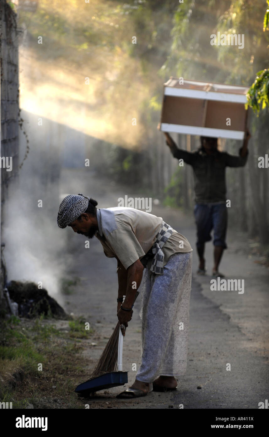 Men at work in the back streets of Sanur , Bali , Indonesia Stock Photo