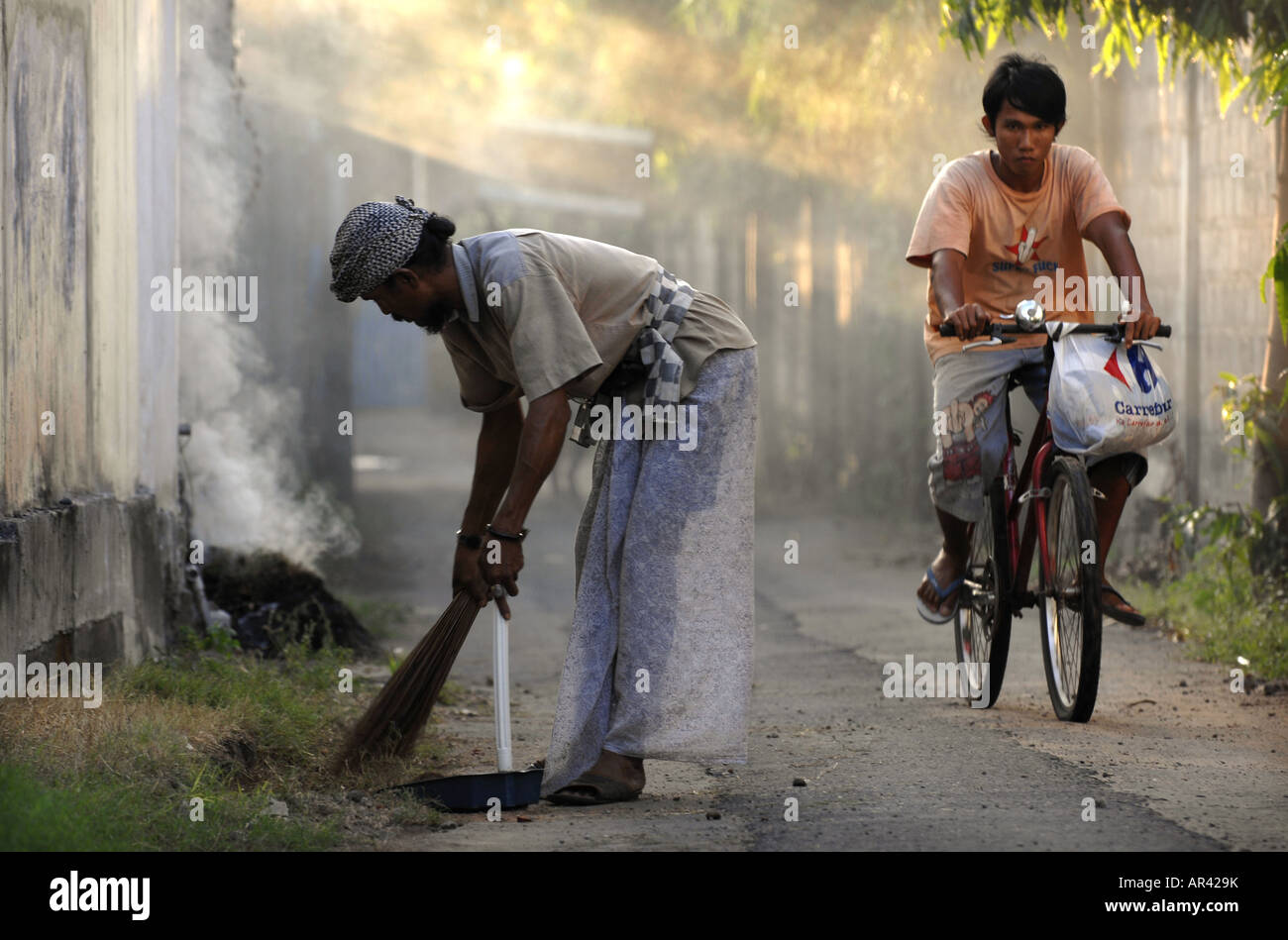 Men at work in the back streets of Sanur , Bali , Indonesia Stock Photo