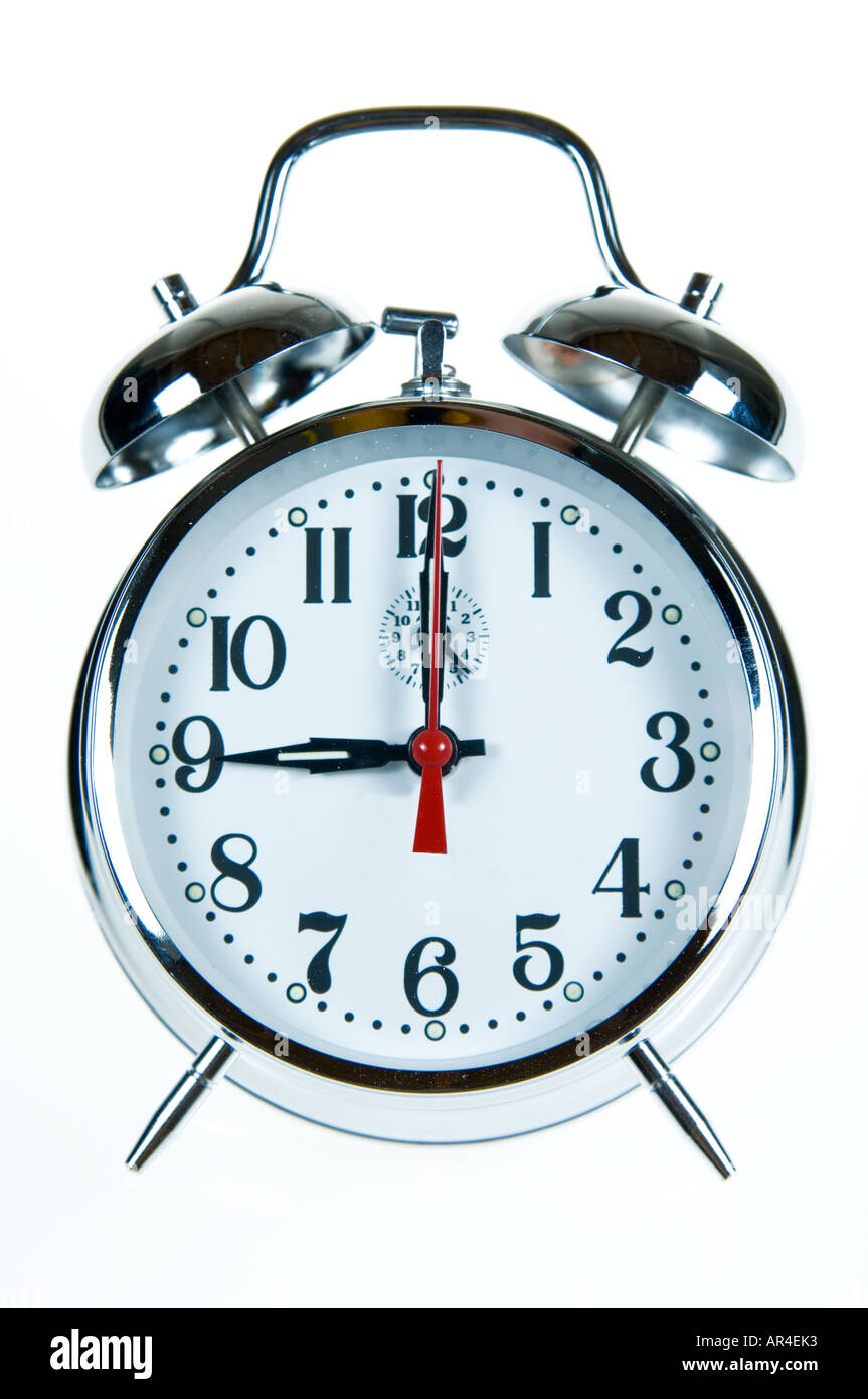 white background shot of an alarm clock showing 9 nine am Stock Photo