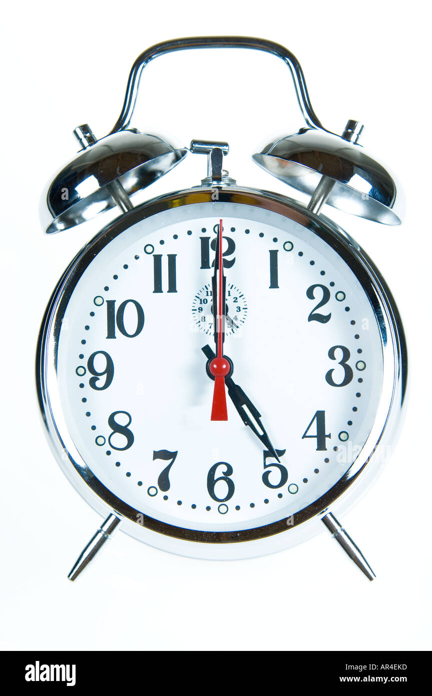white background shot of an alarm clock showing 5 five pm Stock Photo