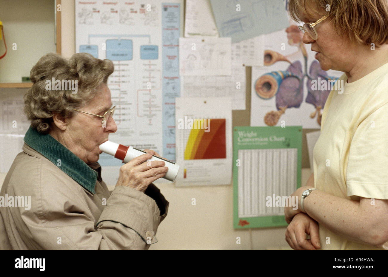 health visitor testing an elderly woman with asthma with a peakflow meter Stock Photo