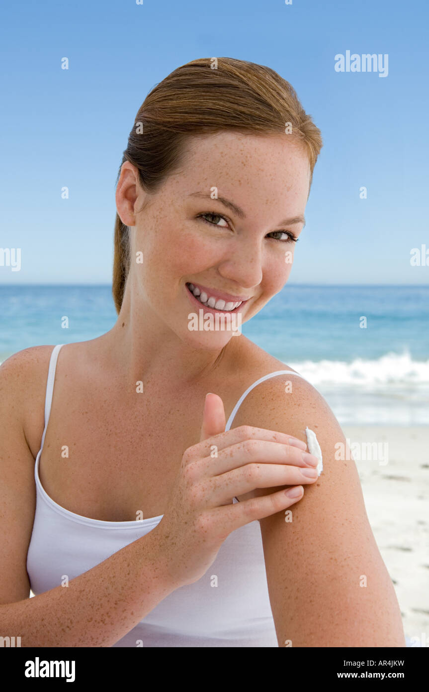 Young woman applying suncream Stock Photo