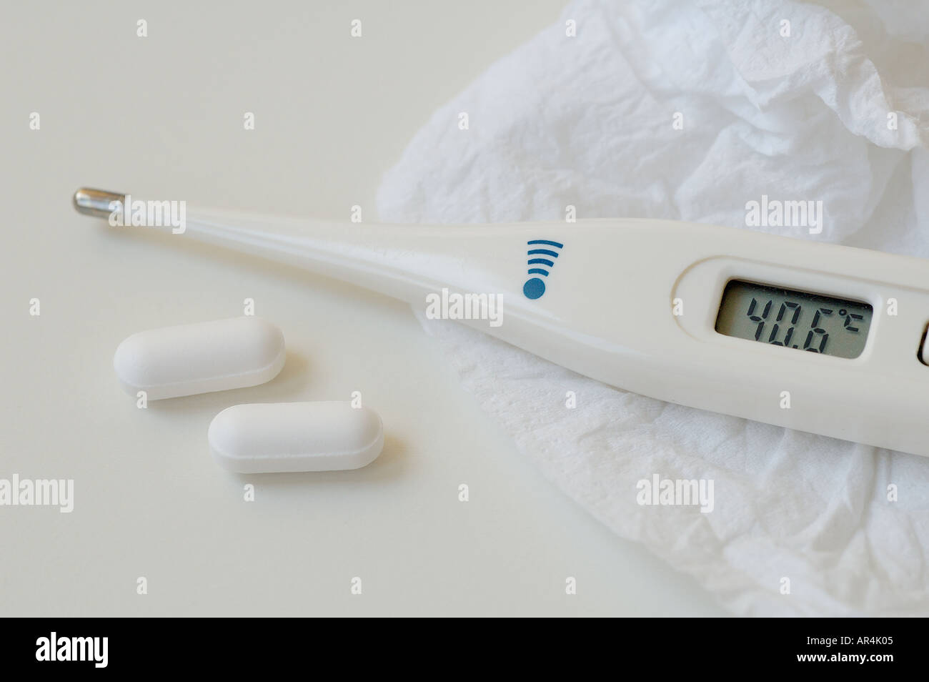 Digital electronic clinical thermometer with medical pills Stock Photo