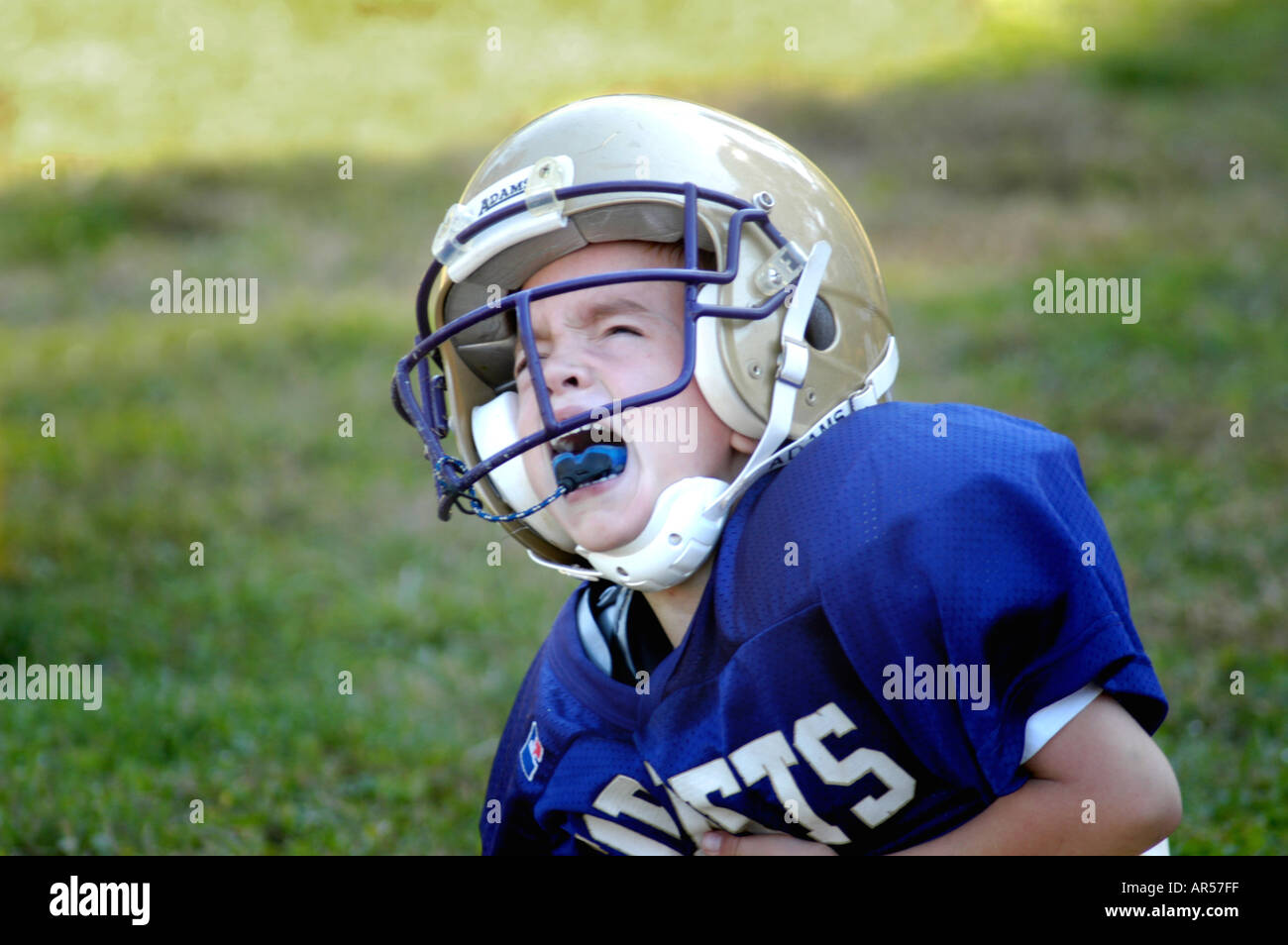 A real boy who was hurt when practicing for Youth Football for 8 year old in Atlanta GA USA crying shouting screaming Stock Photo