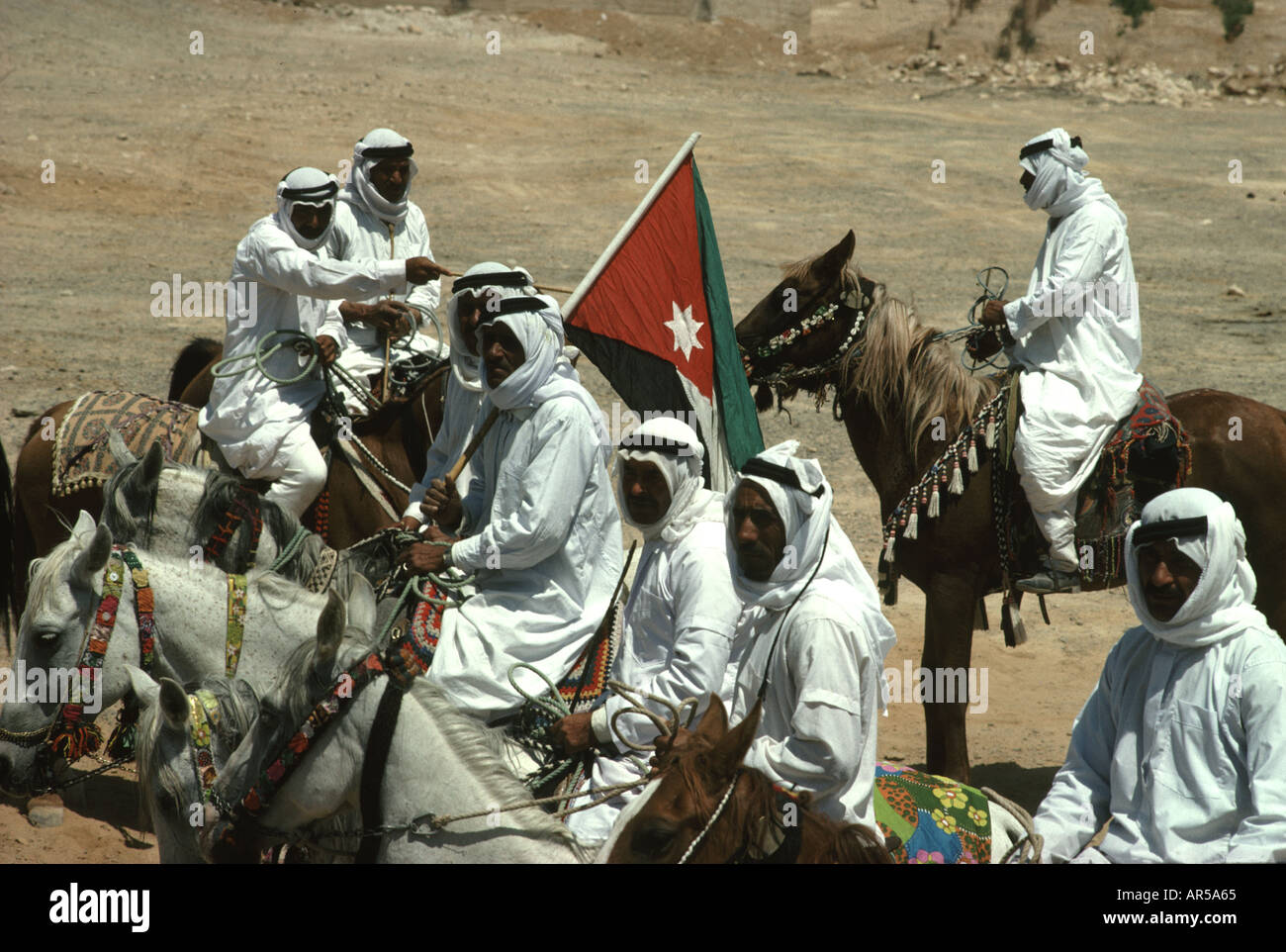 Jordanian arab horsemen and Jordanian flag during celebration in the souther town of Ma an Jordan Stock Photo