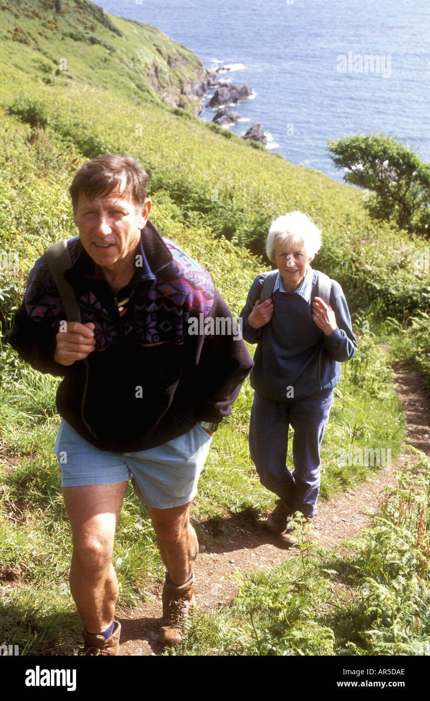 Retired couple walking near Dodman Point near Gorran Haven on the south coast of Cornwall, UK, staycation staycations Stock Photo