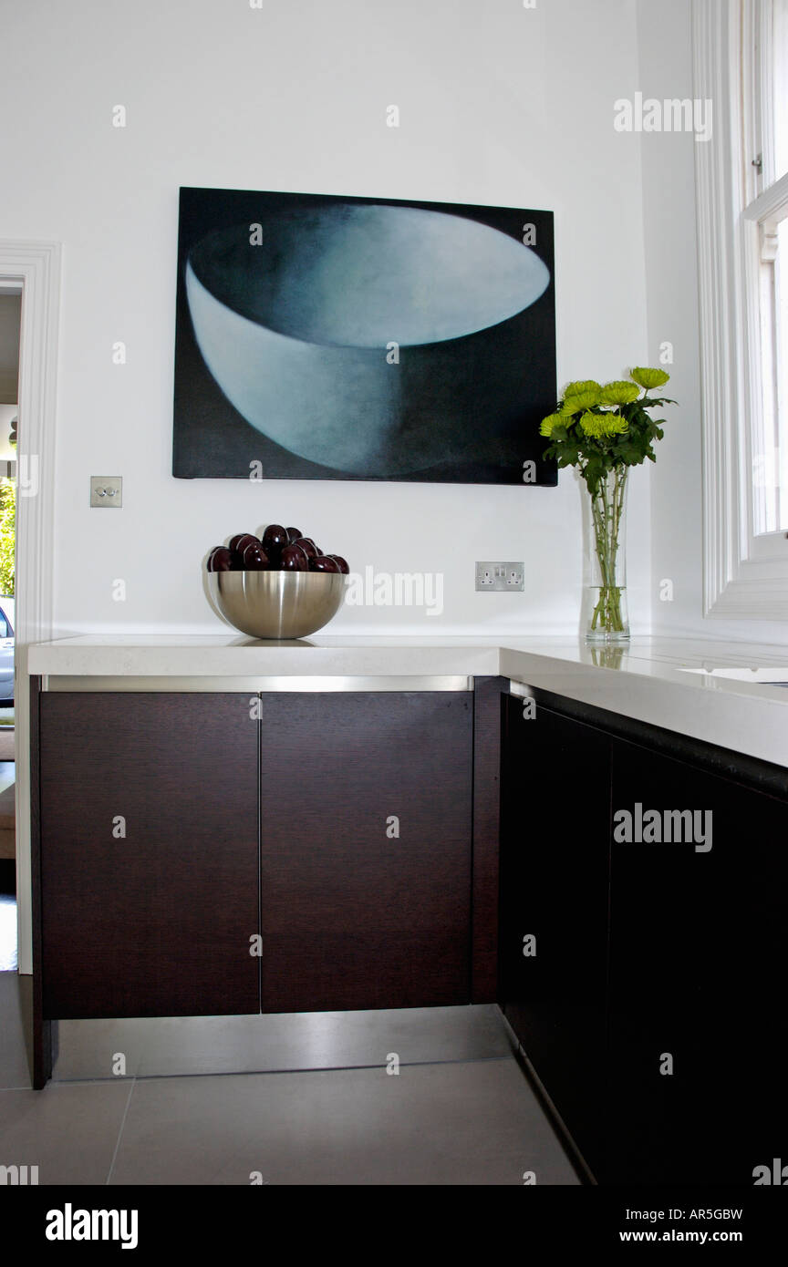 Large abstract painting above worktop in modern black and white kitchen
