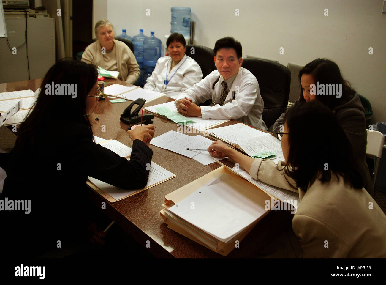 Doctors & staff meet at Vietnamese-American community medical clinic, Garden Grove, California, USA. MODEL RELEASE Stock Photo