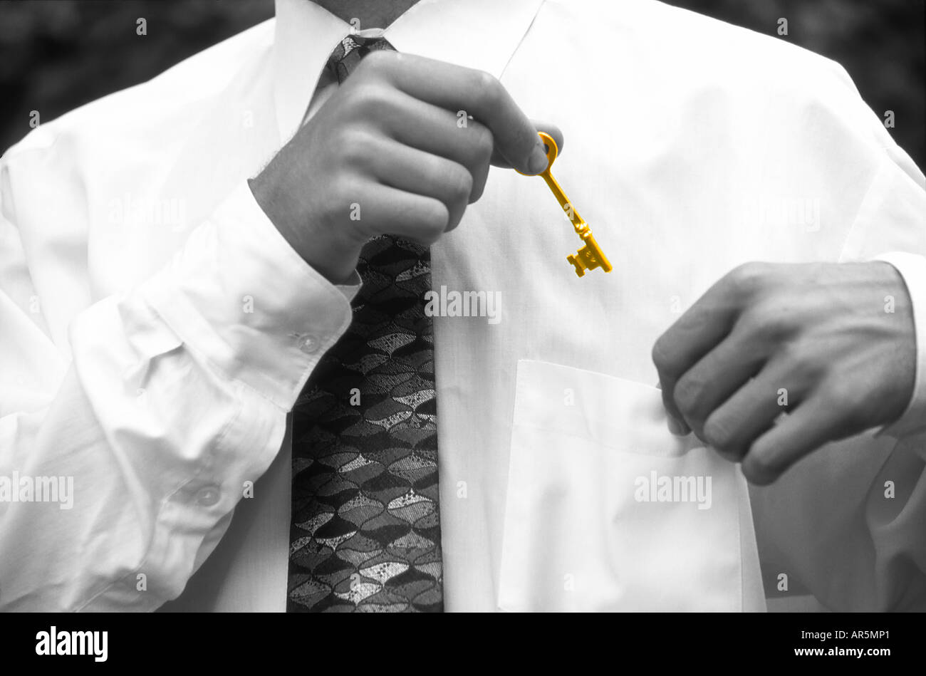 Businessman putting key in pocket Stock Photo