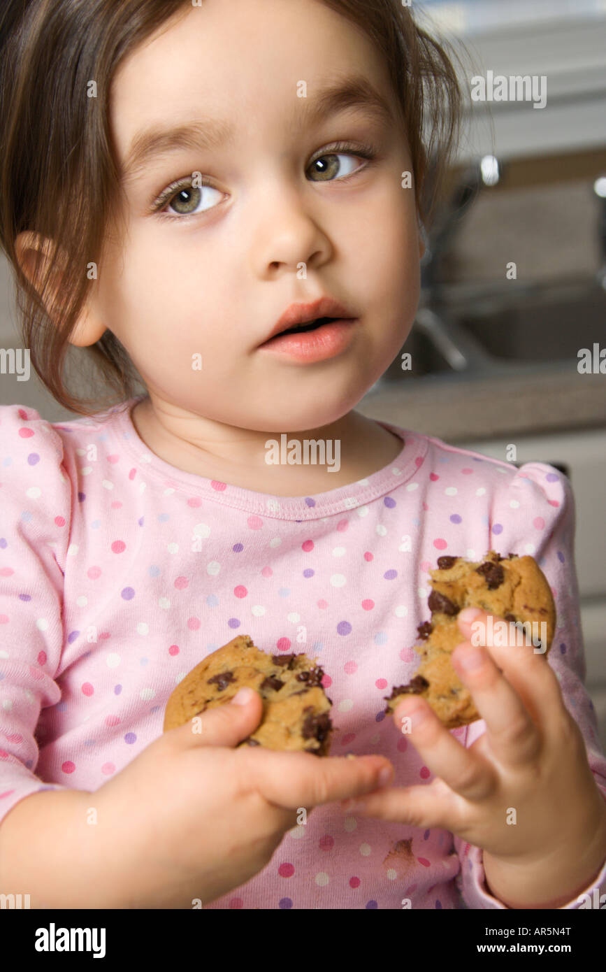 Caucasian girl eating chocolate chip cookie Stock Photo Alamy