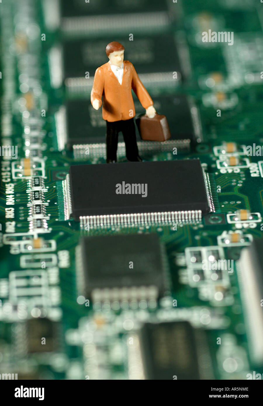 Toy businessmen on computer circuit board Stock Photo