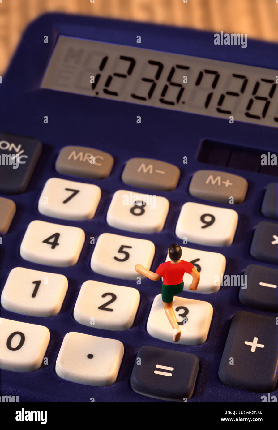 Toy jogger on calculator Stock Photo