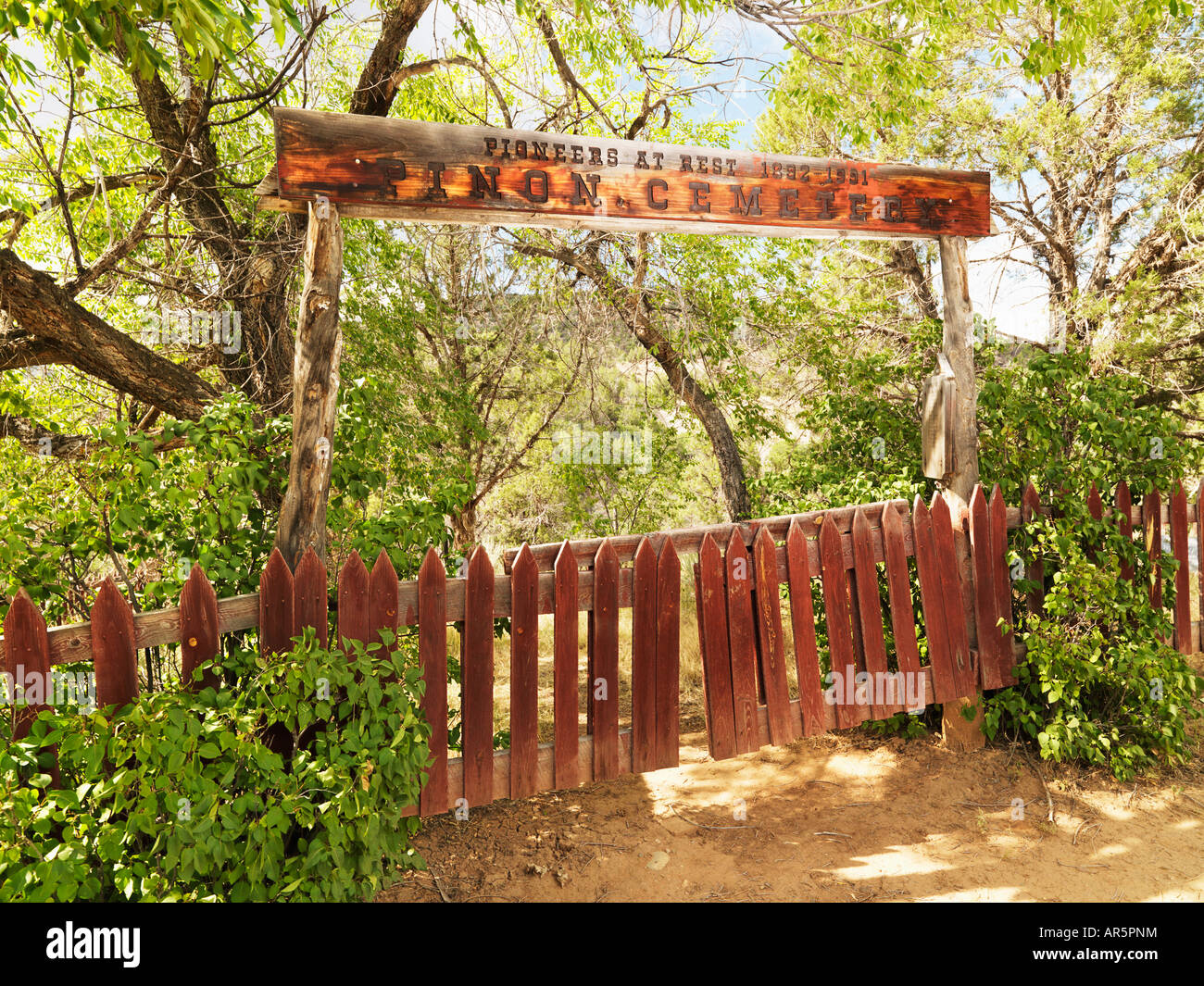 Pioneer cemetery entrance with gate and sign in woods Stock Photo
