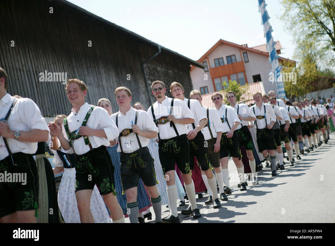 Young men in traditional bavarian clothes at the celebration of 1st May, Muensing, Bavaria, Germany Stock Photo