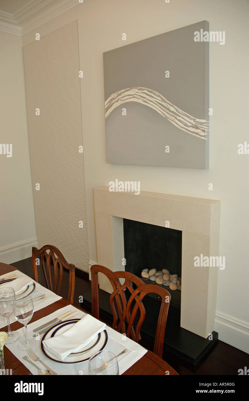 Abstract painting above fireplace in modern dining room with white