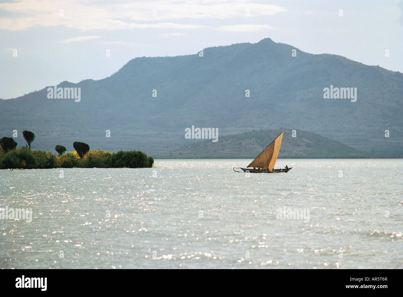 Luo sailing canoe on Lake Victoria with Homa Bay and Homa Mountian in the distance Lake Victoria Kenya East Africa Stock Photo
