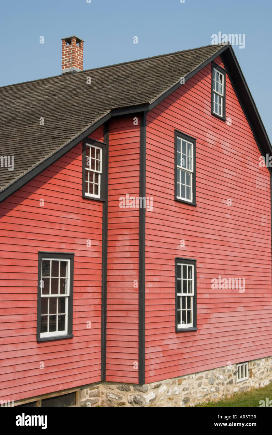 Residential house exterior with weathered red clapboard siding and a