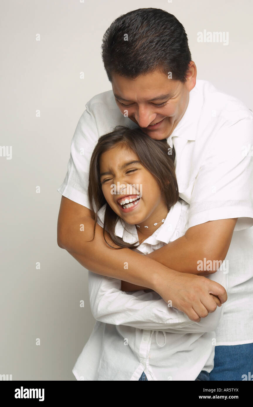 Hispanic father and daughter hugging Stock Photo