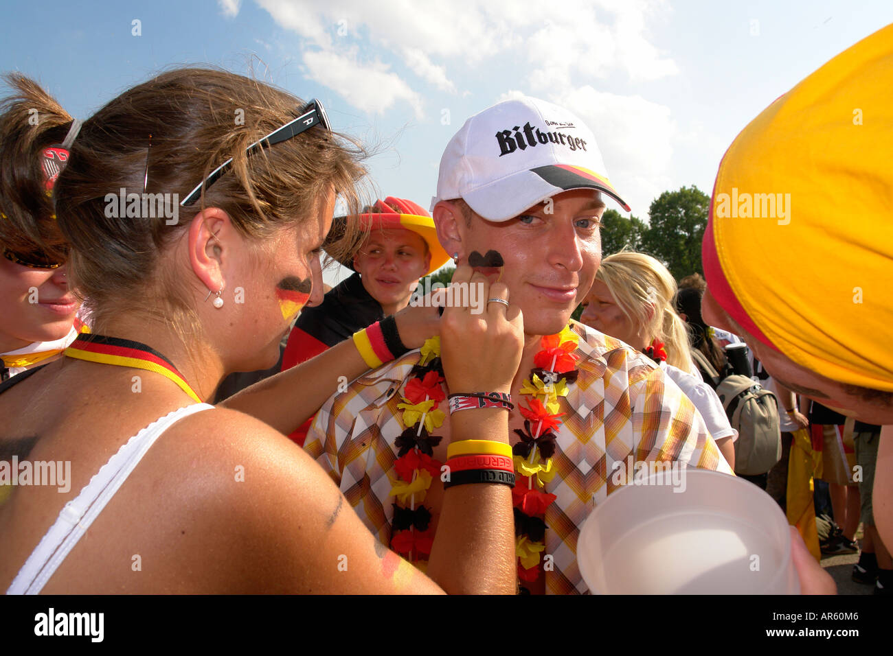 German football fans painting a national heart symbol on his face to support their team in WM Olympia park Munich Germany Stock Photo