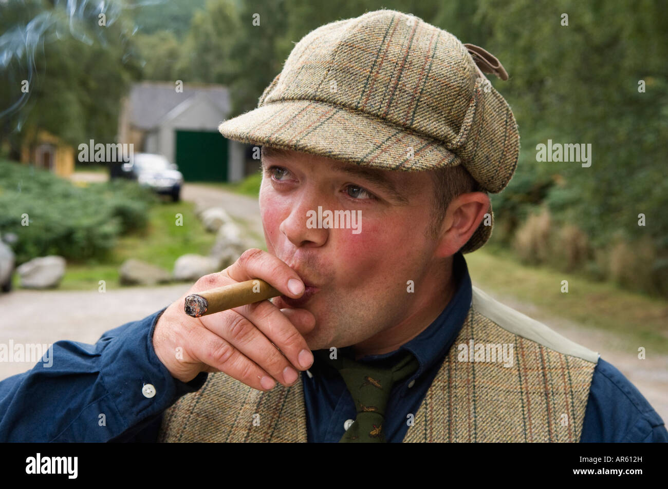 Young Man Smoking a Fine Cigar after a Successful Driven Red Grouse Shoot Near Aviemore Scotland Stock Photo