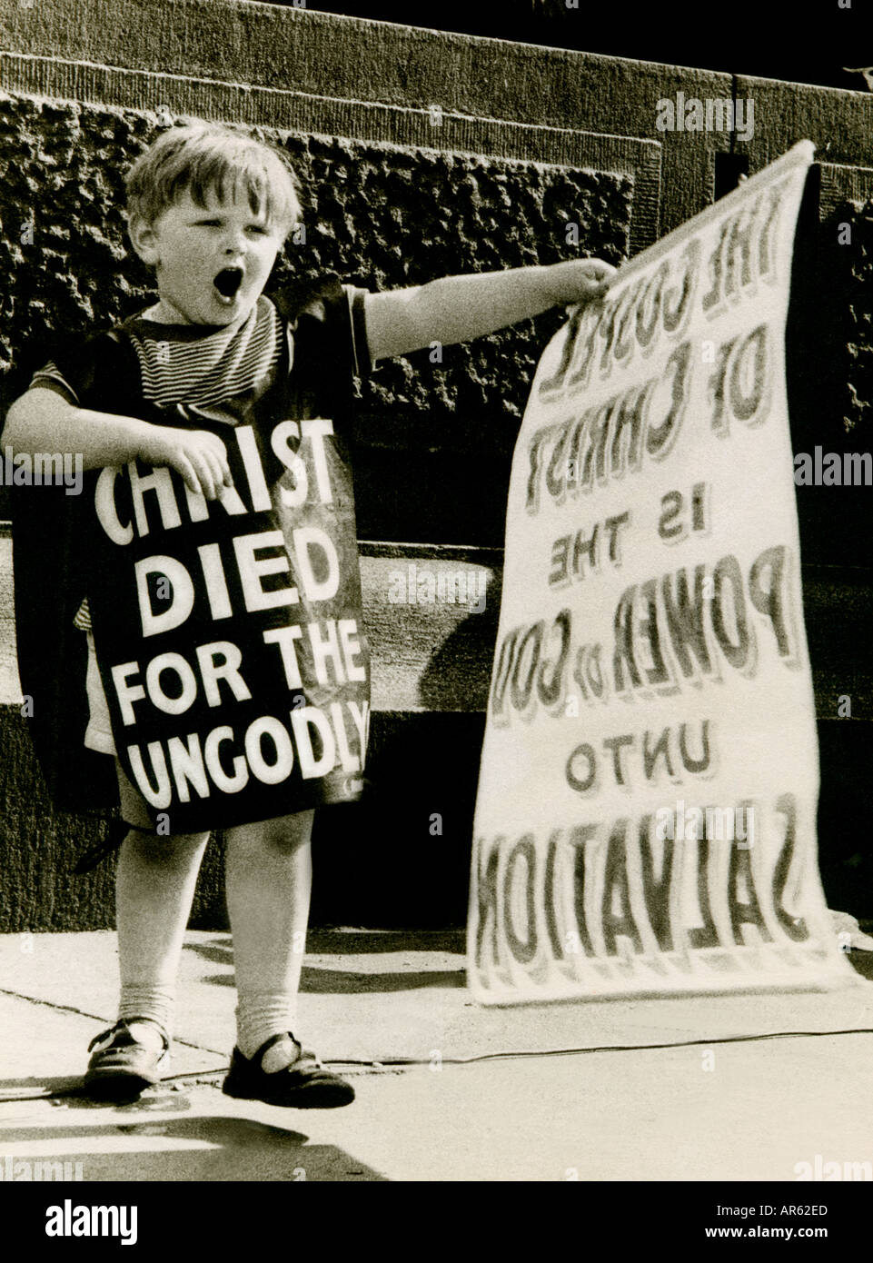 1960’s  RELIGIOUS RALLY UK RADICALISED CHILD BOY 7-9years RADICAL RELIGIOUS FERVOUR  B+W 1960s boy at religious rally waving banner preaching to crowd Stock Photo
