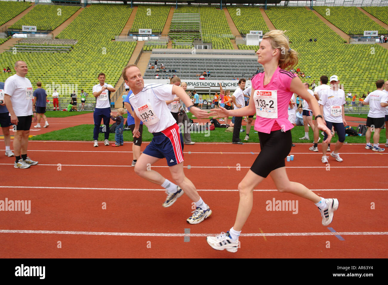 Runners run a relay race at stadium Stock Photo Alamy