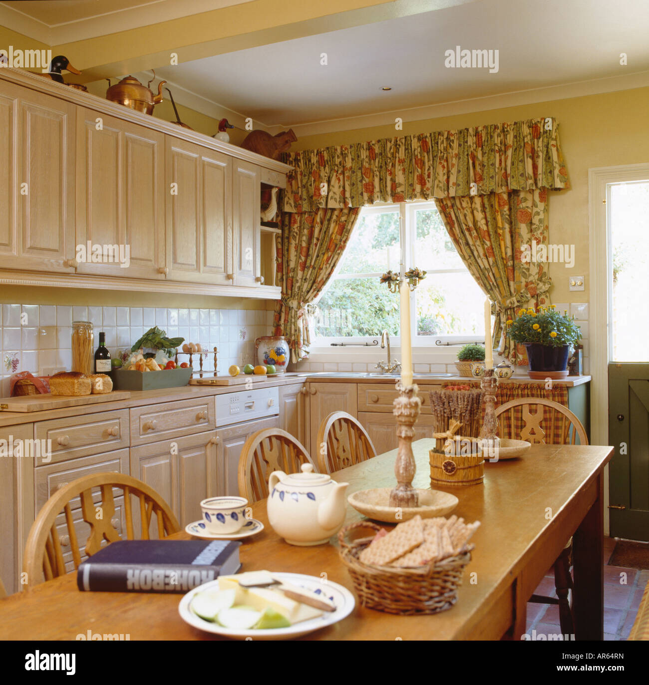 Yellow crockery in nineties economy kitchen with turquoise doors on fitted  units Stock Photo - Alamy