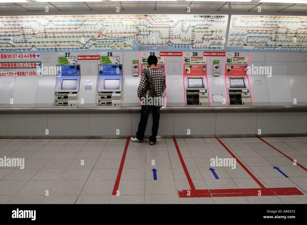Young man in front of the ticket machine of a subway station, Tokyo, Japan Stock Photo
