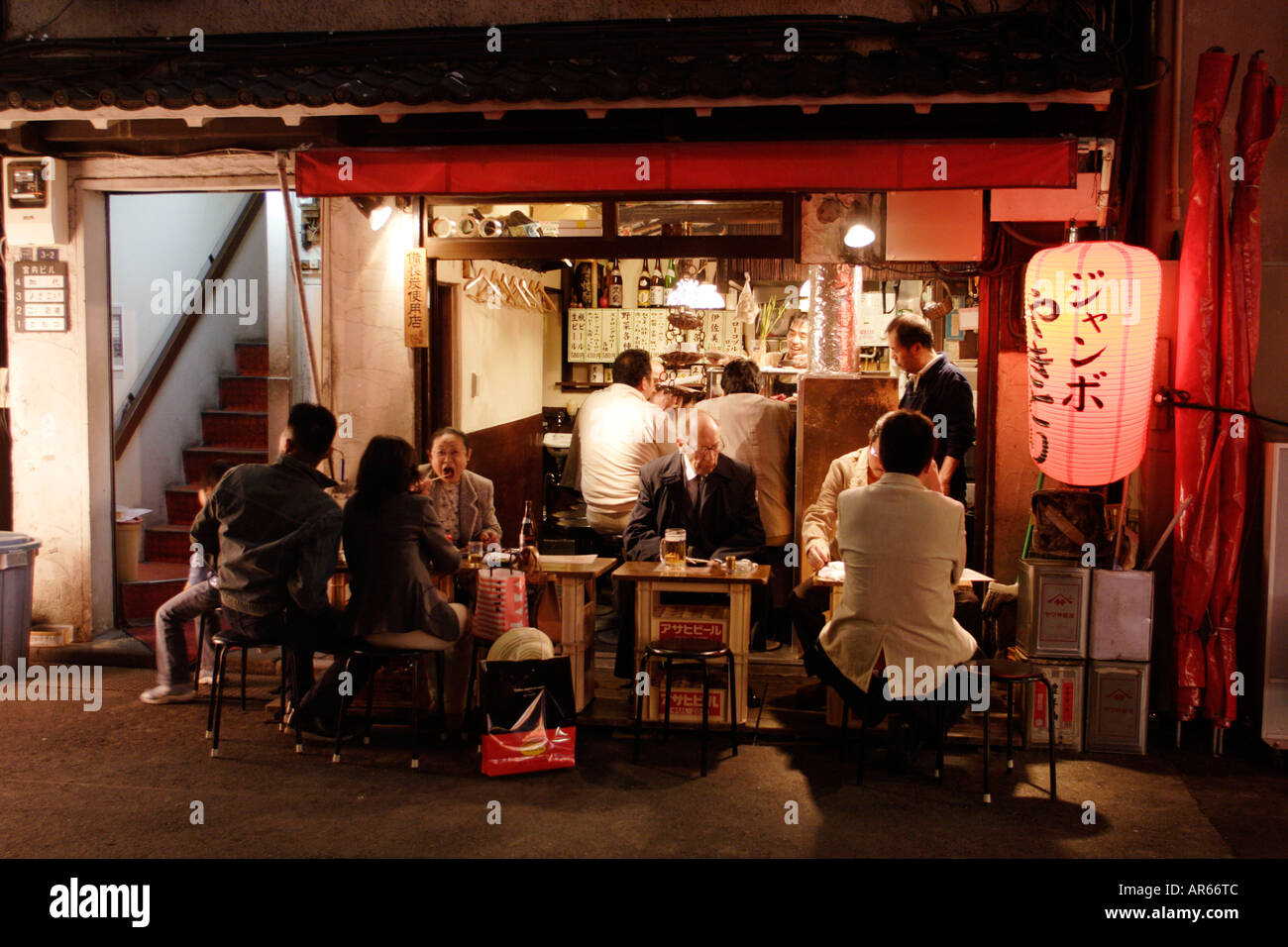 People sitting at a fast food at night, Yurakucho Yakitori Alley Stock