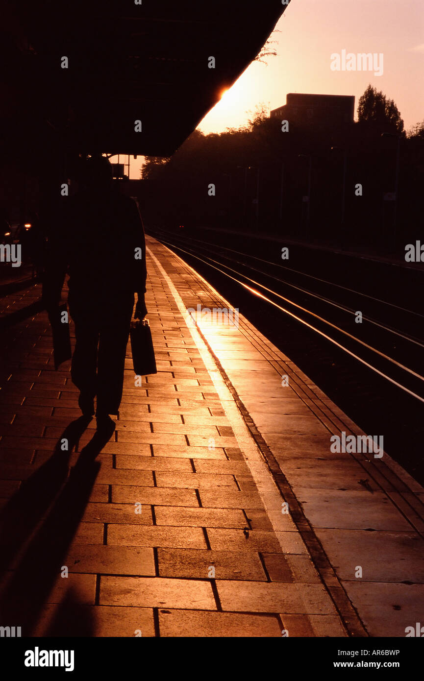 Silhouetted commuter on railroad platform Stock Photo