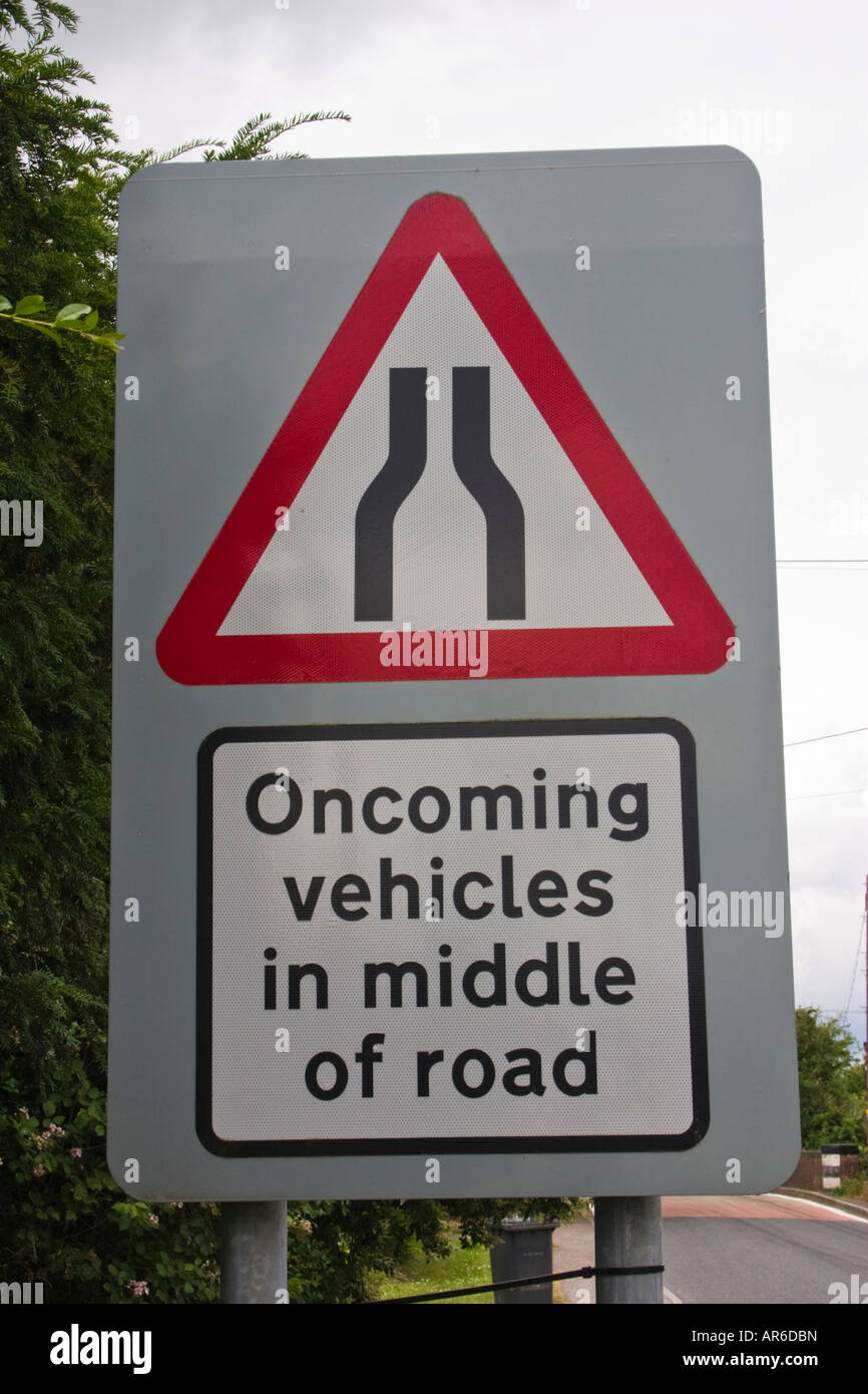 beware oncoming vehicles in middle of road road sign Stock Photo