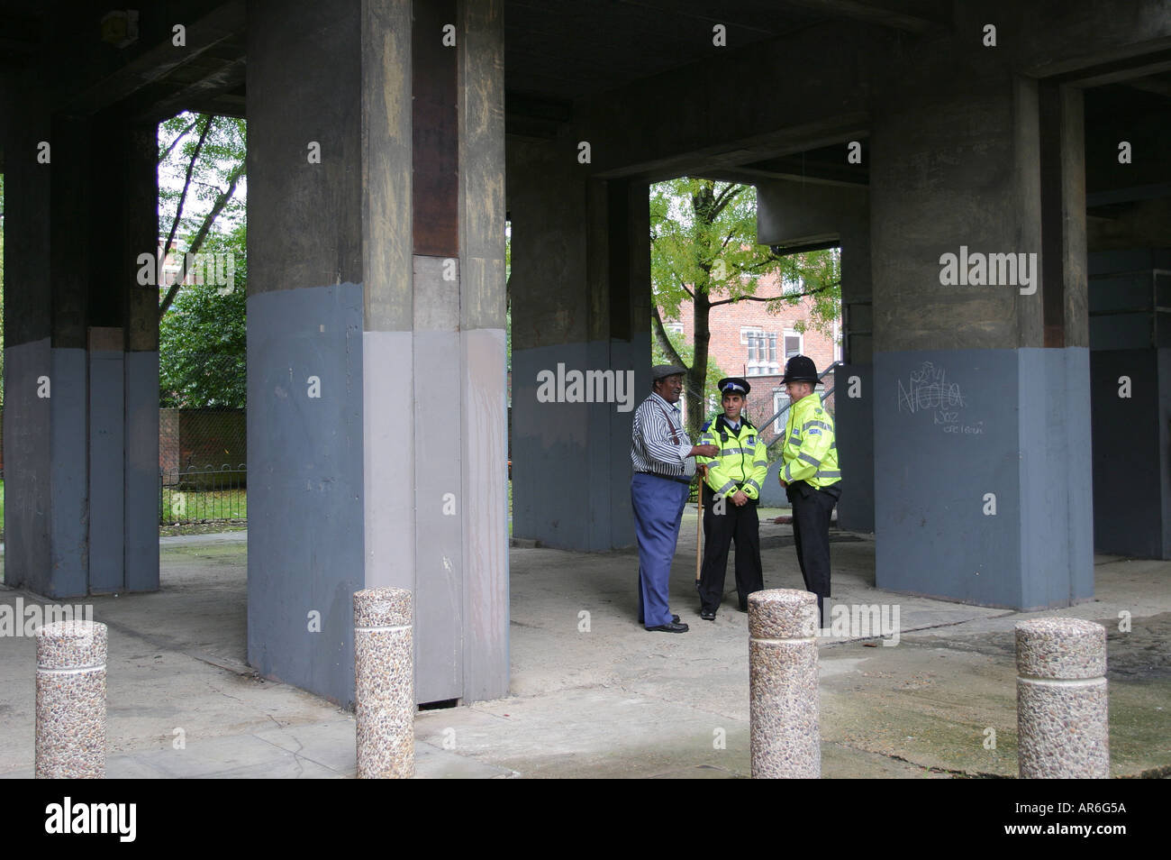 A tenant, a Community Support Officer and a Police Officer discuss anti-social behaviour on a housing estate London UK Stock Photo