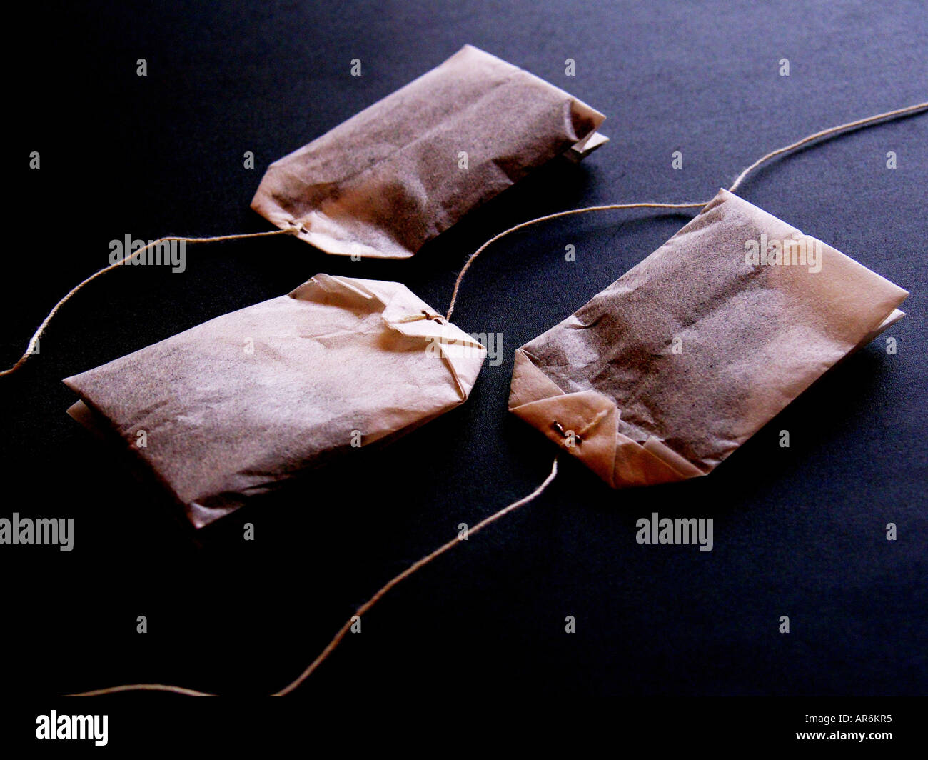 Three fresh teabags in soft dreamy light and subtle color. Stock Photo