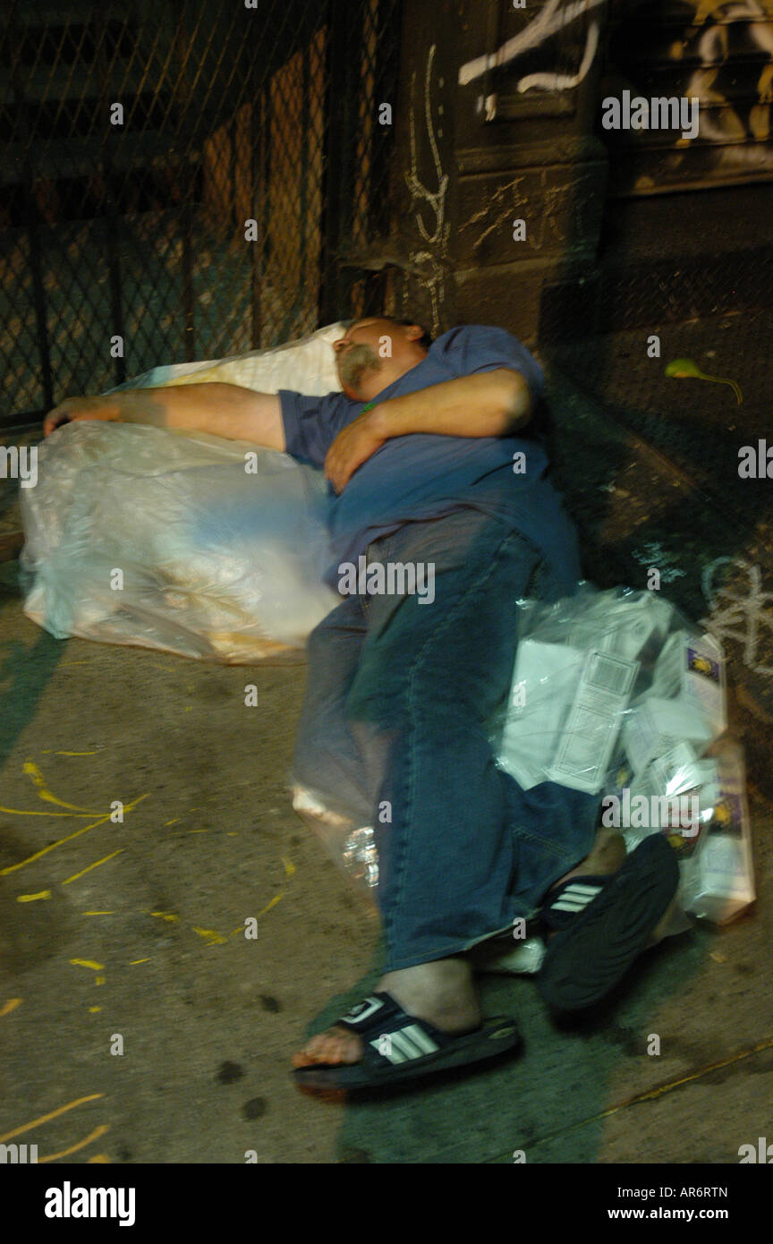 Homeless lying on a pile of garbage East Village New York USA Stock Photo