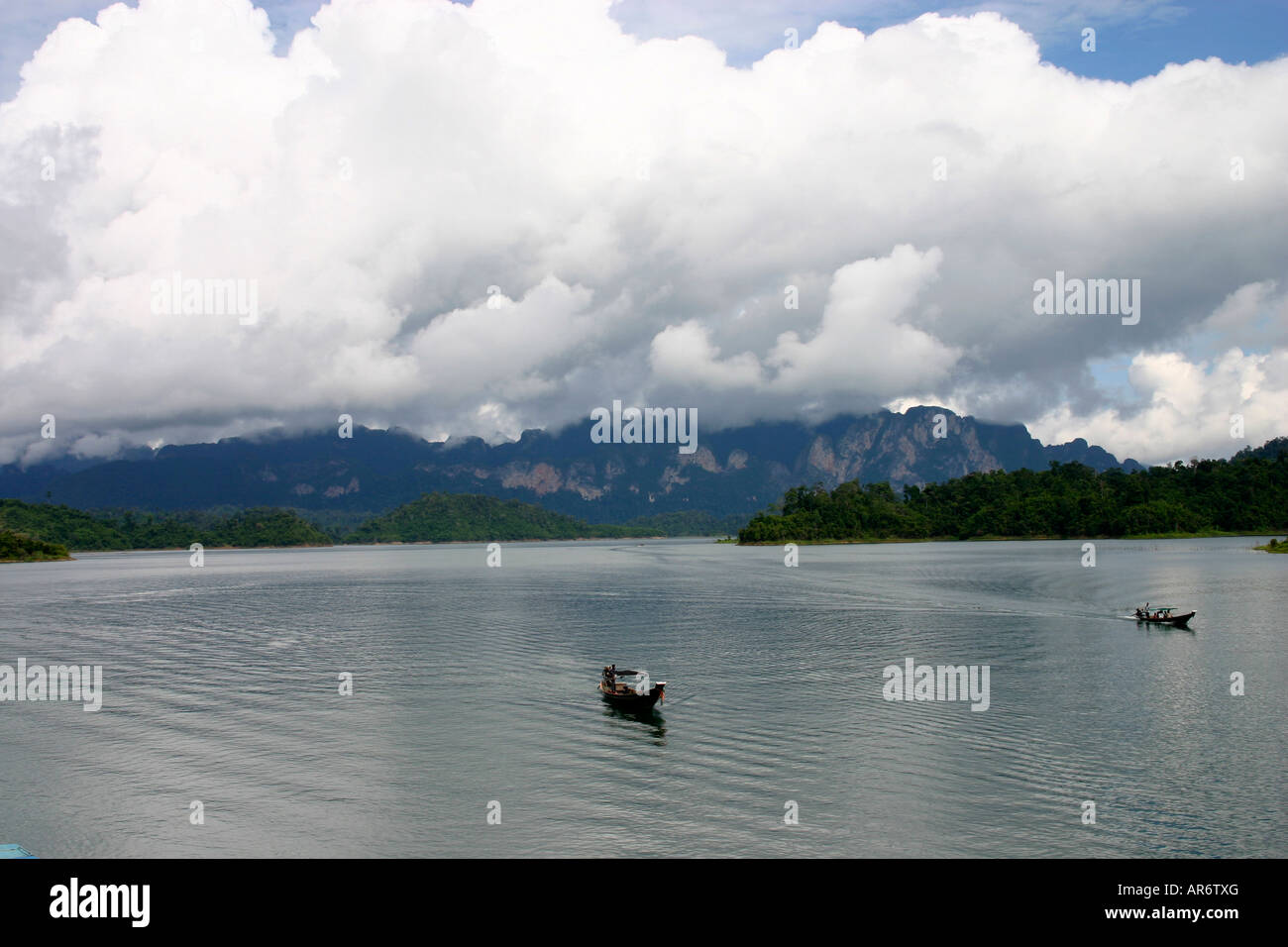 Landscape detailing a boat floating on a dam in Thailand Stock Photo