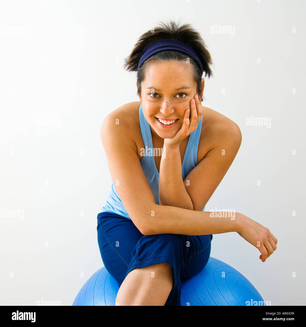 Portrait of young woman sitting on fitness balance ball smiling Stock ...