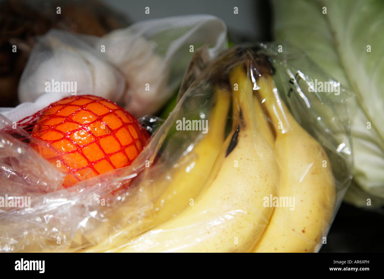 Close up of mandarin garlic cabbage and bananas in plastic bag Stock