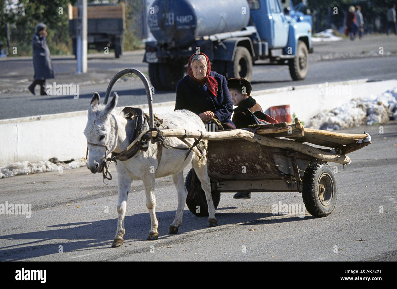 A woman and her grandson drive to town in a donkey drawn cart in Simkent Stock Photo