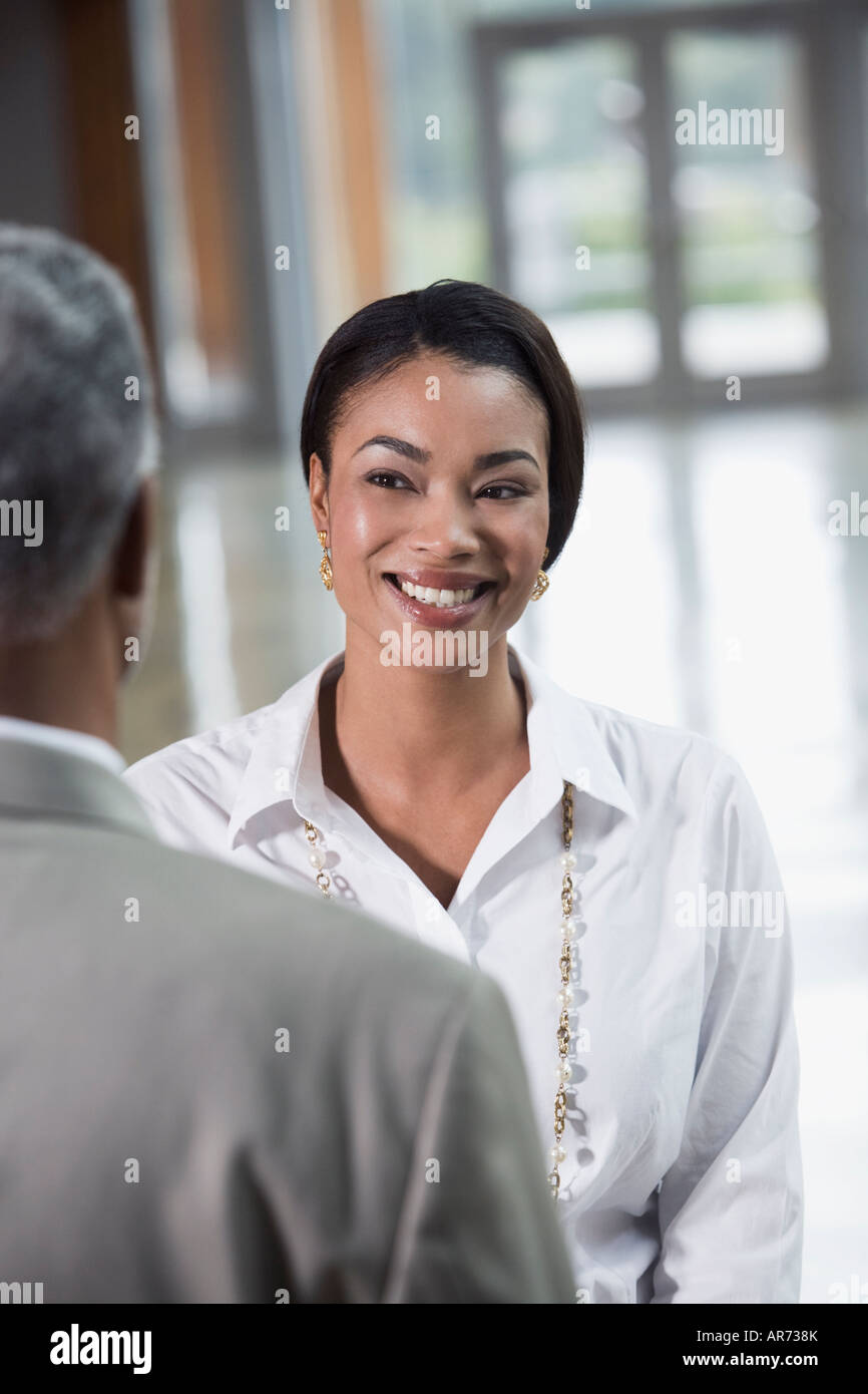 African businesswoman smiling at coworker Stock Photo