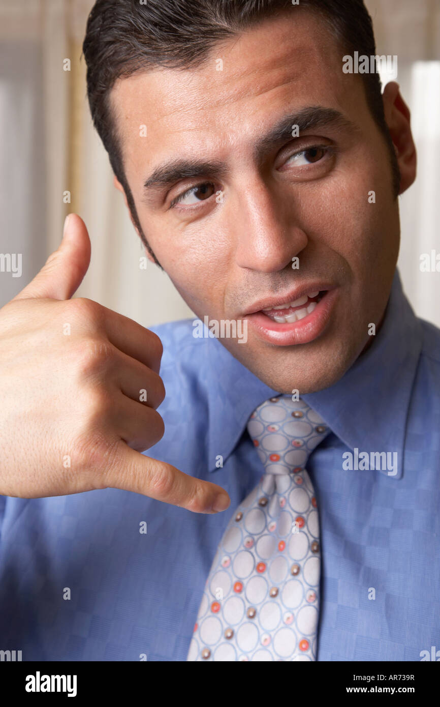 Hispanic businessman mimicking telephone with hand Stock Photo